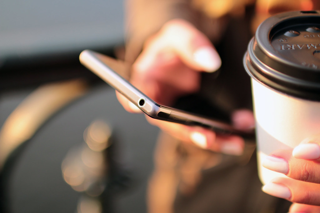 Smartphone tenu en main affichant des applications